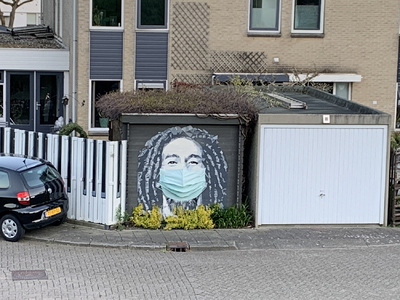 NOC-Covid-19-007 Schildering op een garagedeur: hoofd met dreadlocks en mondkapje.